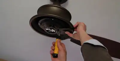Electrician installing ceiling fan mounting bracket and fixture in Las Vegas, NV