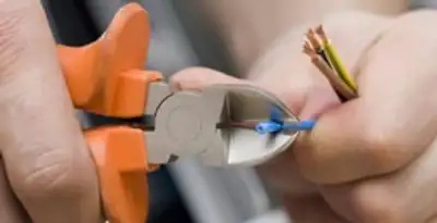 licensed electrician performing precise wire cutting and preparation during electrical service in Las Vegas, NV