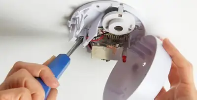Certified technician wiring smoke detector during installation in Las Vegas, NV